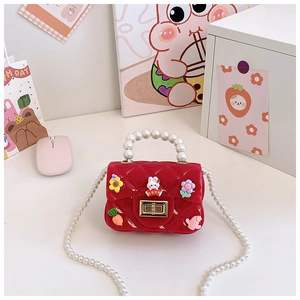 Détail du mini sac rouge en silicone avec breloques cartoon et poignée en perles