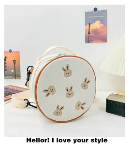 Détail du sac rond en toile pour enfant avec broderie lapin et bordure en cuir brun