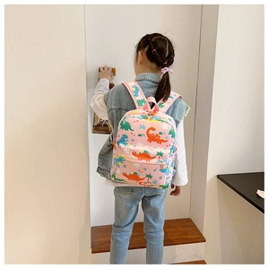 Pink cartoon dinosaur backpack for kids showing comfortable fit and shoulder straps detail