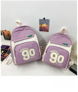 Détail de sacs à dos en toile violet et beige en deux tailles avec imprimés basketball