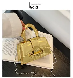 Detail of gold mini handbag featuring mirror finish and pearl bead shoulder strap