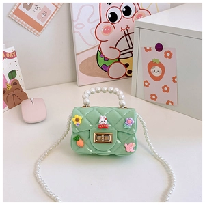 Détail du sac en silicone vert menthe avec anse en perles et décors de lapin lapin