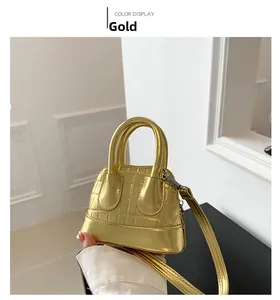 Detailed view of mini gold shell bag with crocodile texture and detachable shoulder strap