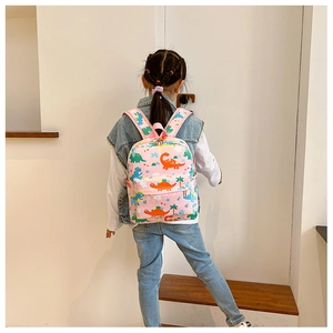 Toddler backpack with colorful dinosaur prints shown on a child model in a modern room