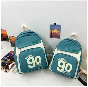 Détail de deux sacs à dos en toile bleu et blanc avec motifs de lettres de basket-ball