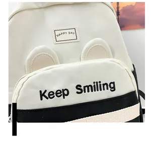 Detail of kindergarten backpack featuring cat ears design and keep smiling embroidery