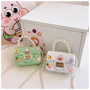 Détail du mini sac en silicone avec texture matelassée, poignée perle et lapin de dessin animé