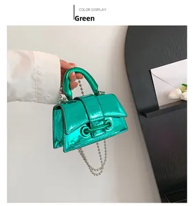 Detail of glossy green mini handbag with metallic finish and beaded chain strap