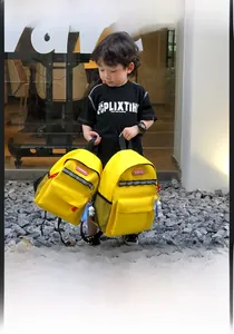 Detail of yellow kids canvas backpack with reflective strips and astronaut charm