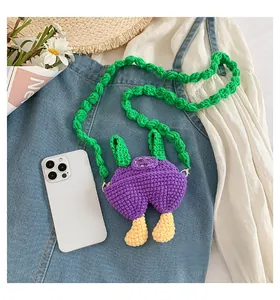 Size comparison of a mini purple handmade crochet crossbody bag next to a smartphone