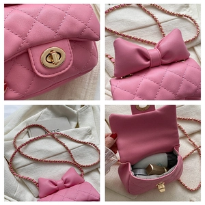 Detail view of pink quilted mini crossbody bag with bow accent and gold chain strap