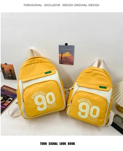 Détail de sacs à dos en toile jaune et blanc avec imprimé lettres BASKETBALL 90