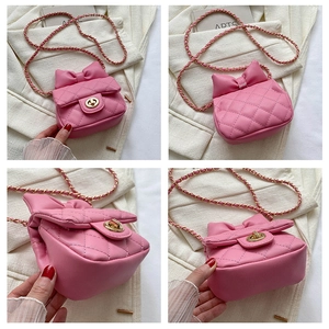 Detail view of pink quilted mini crossbody bag with a large bow and gold chain strap