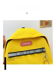 Detail of yellow canvas backpack featuring FASHION-BAG label and reflective safety strap