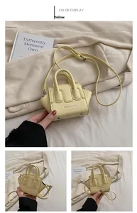 Dettaglio mini borsa a conchiglia gialla in pelle PU con scritte FASHION & BAG