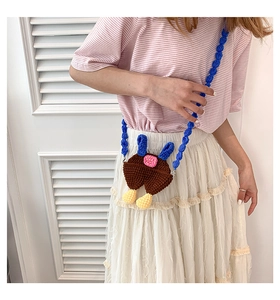 Detailed close-up of handmade crochet mini crossbody bag with overall trousers design