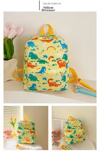 Detail of yellow toddler backpack featuring colorful dinosaur prints and front zipper pocket
