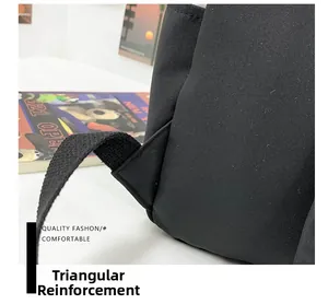 Detail view of reinforced triangular stitching on black canvas backpack shoulder straps