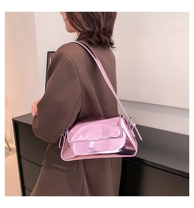 Detail einer glänzenden rosa Lackleder-Umhängetasche mit elegantem rechteckigem Klappdeckel