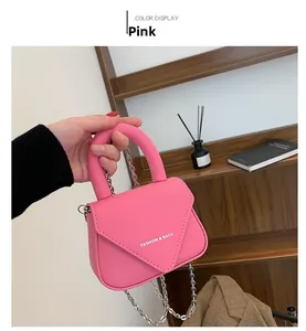 Detailaufnahme der rosa Lederhandtasche mit Silberkette und weißem Logo-Schriftzug