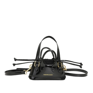 Glossy black patent leather mini shell bag with gold hardware and adjustable strap