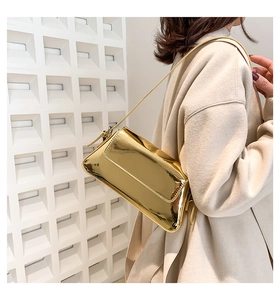Nahaufnahme der goldenen Umhängetasche mit Spiegeleffekt an einem Model mit modernem Design