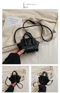 Dettaglio della mini borsa a trapezio nera con manici e tracolla regolabile