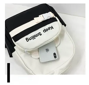 Detail of the front pocket on a black canvas backpack showing storage capacity for a smartphone