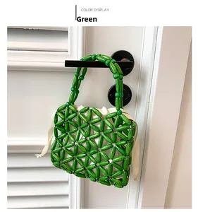 Detail of green handmade beaded woven handbag with beige drawstring silk lining pouch