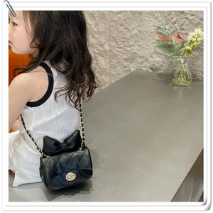 Girl's black mini crossbody bag featuring quilted leather and a large decorative bow detail