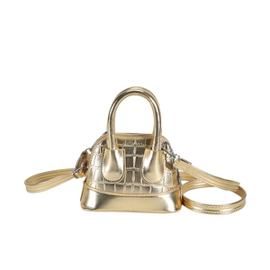 Mini golden shell bag with crocodile pattern and adjustable strap on white background