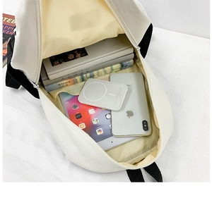 Top view of open canvas backpack interior showing large capacity for books and tablet