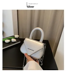 Detailansicht der silbernen Metallic-Minitasche mit Fashion-Text und Kettenriemen