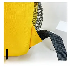 Close-up of yellow canvas backpack showing reinforced triangle stitching and side mesh pocket