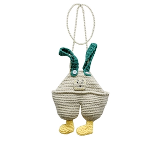 Handmade crochet overall-shaped crossbody bag with pearl strap and cartoon face detail