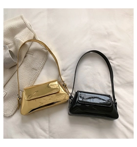 Flache Detailansicht minimalistischer Macaron-Schultertüten in Gold und schwarzem Lackleder