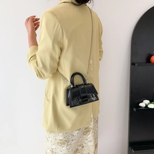 Glossy black patent leather mini handbag with top handle and metal chain shoulder strap