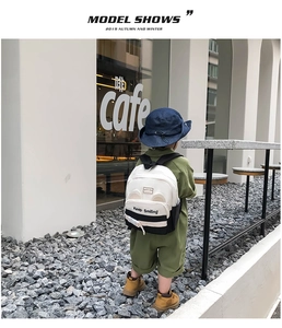 Detail of child backpack featuring bear ears, black-white contrast, and Keep Smiling text