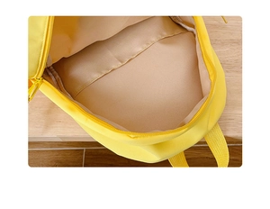 Detailed view of the spacious inner compartment and interior pocket of the yellow backpack
