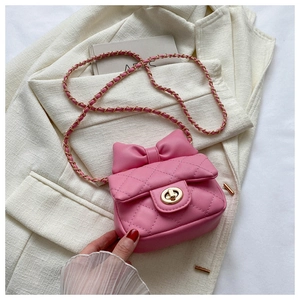 Detail of pink quilted mini bag for girls with bow decoration and gold chain strap