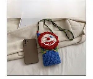 Detailed comparison of handmade crochet clown bag size with a mobile phone