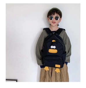 Close-up of a black canvas backpack for kids featuring a cute yellow duck cartoon design