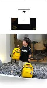 Outdoor shot of a yellow kids canvas backpack featuring a cute white bear pendant charm
