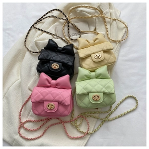 Detail of four colorful mini quilted crossbody bags with bow accent and chain straps
