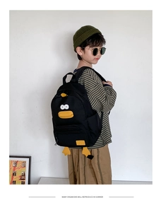 Detail of black canvas backpack with cartoon duck 3D elements for kids outdoor use