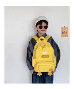 Kid wearing yellow cartoon duck canvas backpack showing side pocket and stable straps