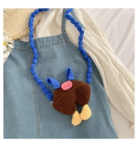 Detail of handmade crochet animal crossbody bag with cute blue overall trousers design