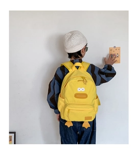 Detail of cartoon duck backpack with adjustable straps and front pocket on a child
