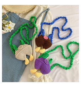 Flat lay of handmade crochet mini crossbody bags in various colors on denim fabric