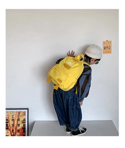 Detail of yellow cartoon duck backpack with durable canvas fabric and 3D decorative feet